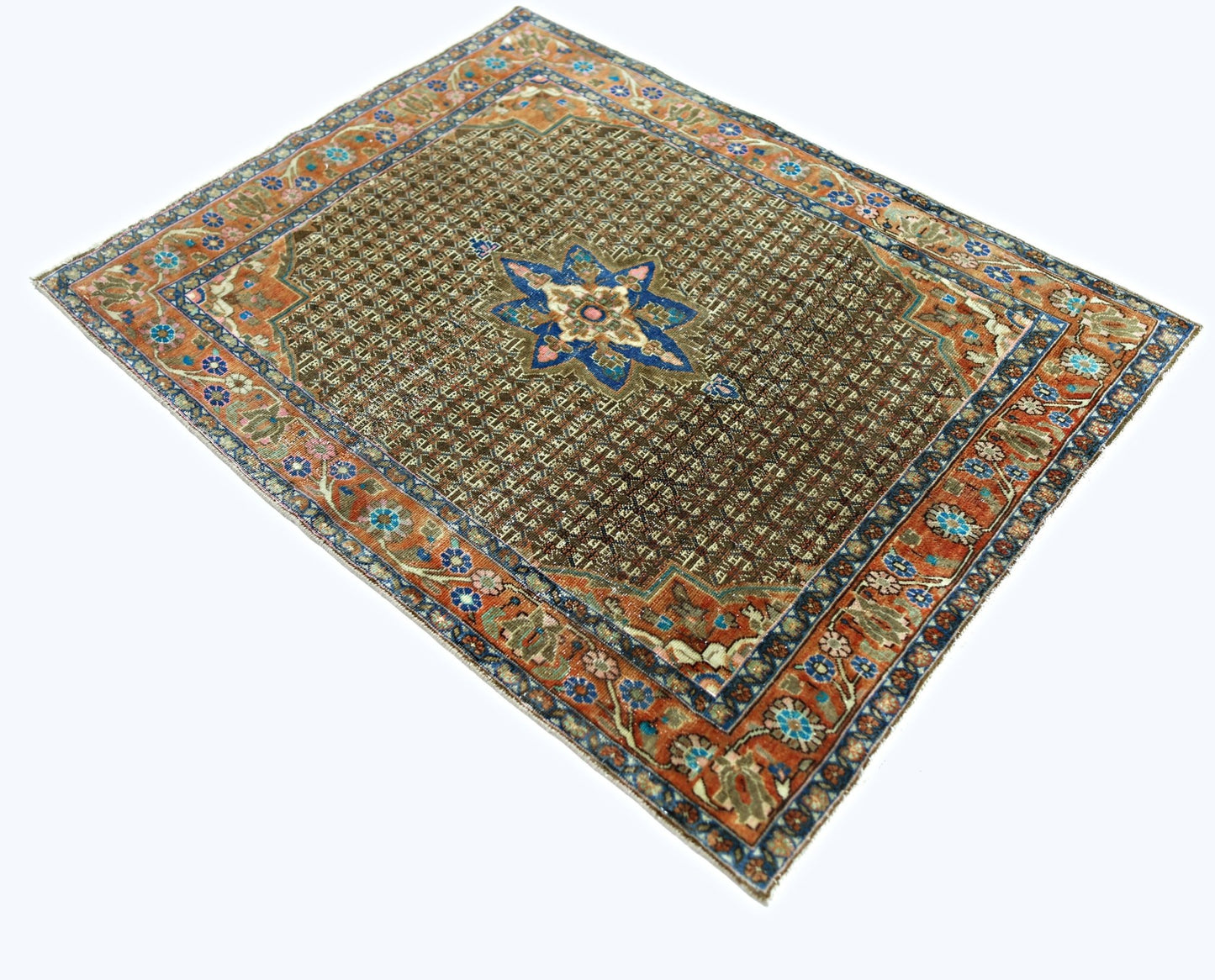 A vintage handmade Persian rug featuring a central star medallion on a brown geometric field.