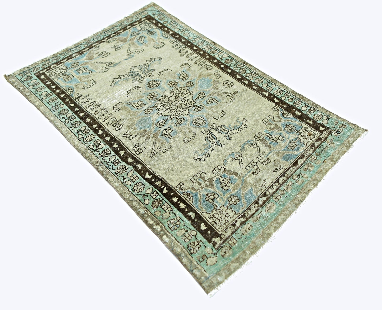 A vintage handmade Persian rug featuring a faded floral pattern in blue and brown on a beige base.