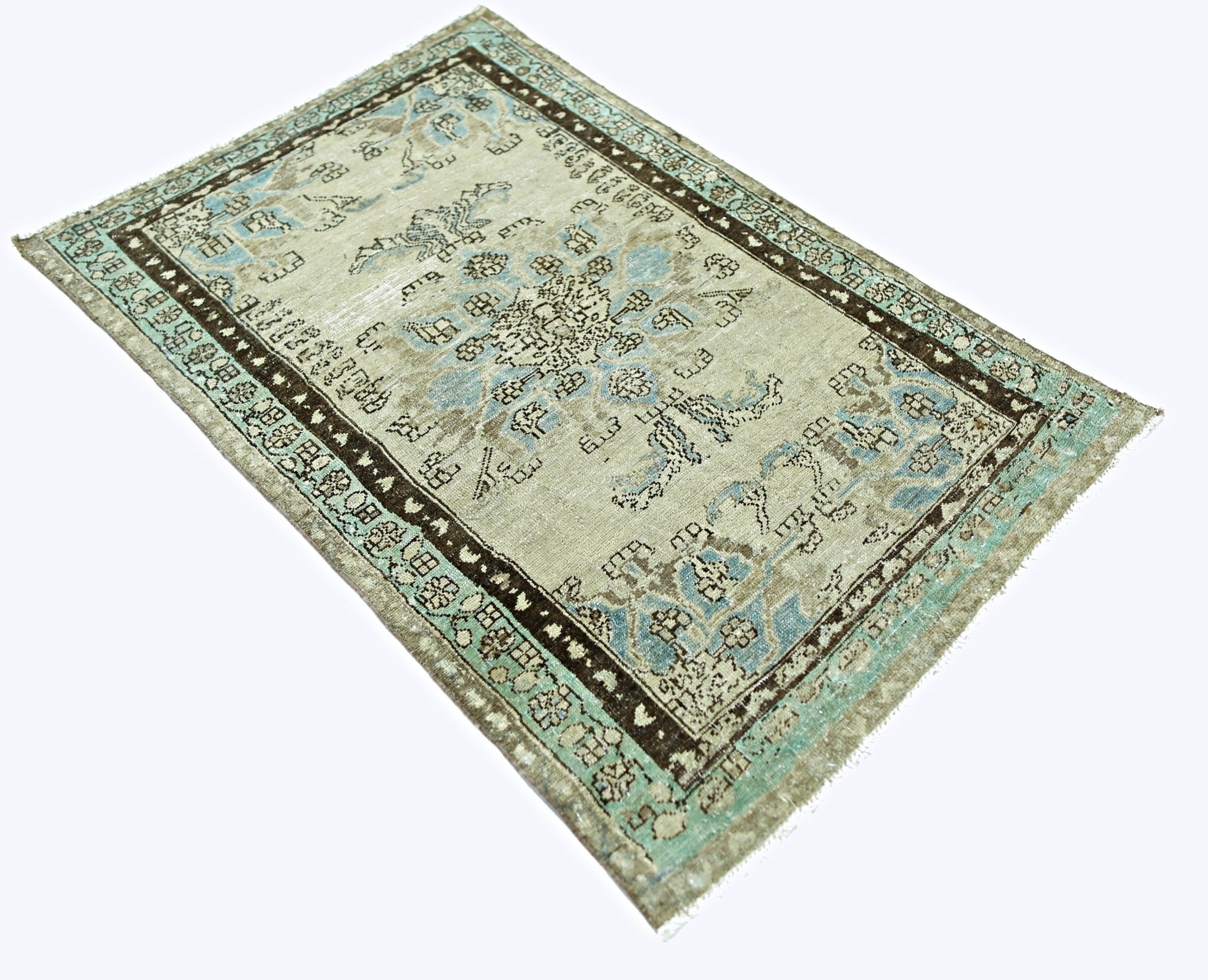 A vintage handmade Persian rug featuring a faded floral pattern in blue and brown on a beige base.