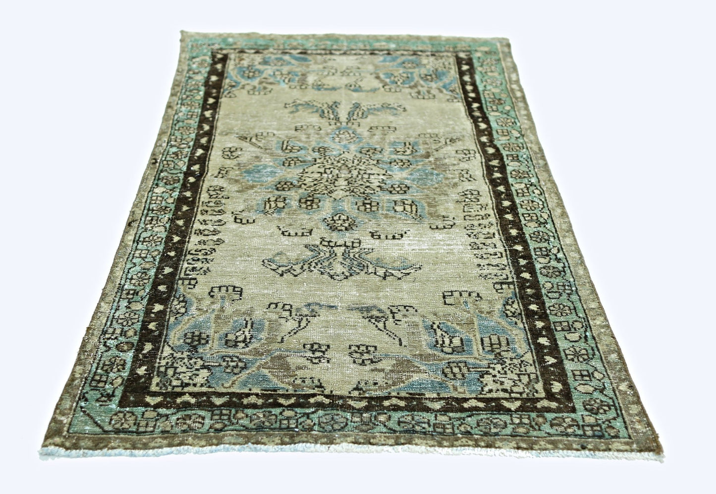 A vintage handmade Persian rug featuring a faded floral pattern in blue and brown tones.