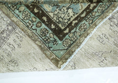 A corner of a vintage Persian wool rug folded over to show its intricate blue and brown pattern.