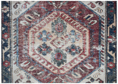 A handwoven vintage Persian rug featuring a central geometric medallion in red, blue, and cream.