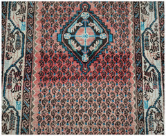 A vintage handwoven Persian rug featuring a central diamond medallion on a pink paisley field.