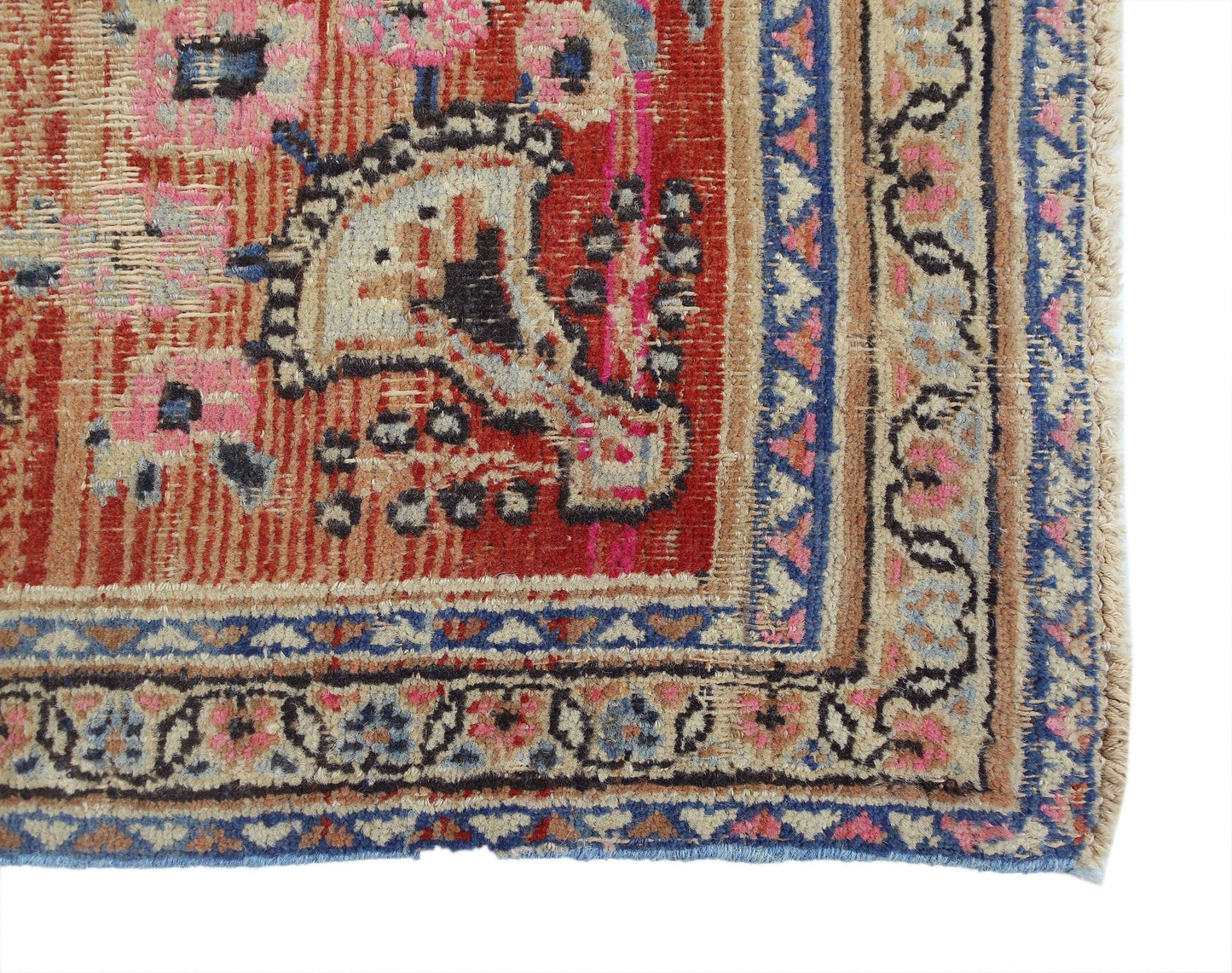 A vintage Persian rug featuring a red field with intricate floral patterns and a blue border.