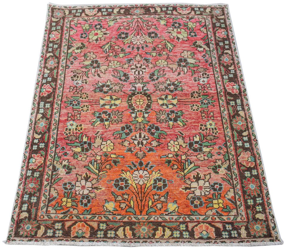 A handwoven vintage Persian rug featuring a floral pattern in shades of red, orange, and brown.