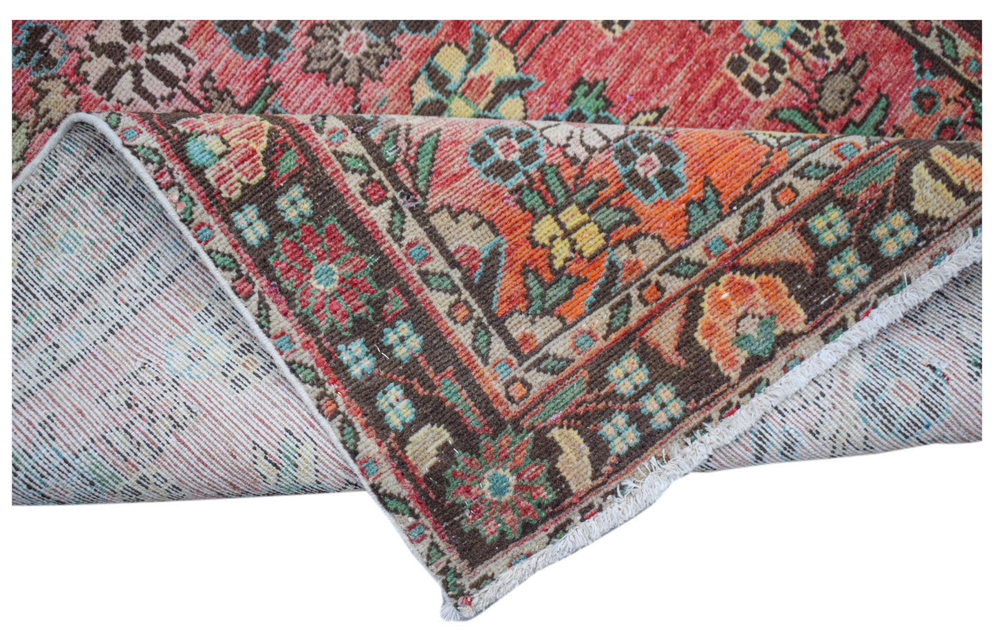 A handwoven vintage Persian rug featuring a floral pattern in red, orange, and brown tones.
