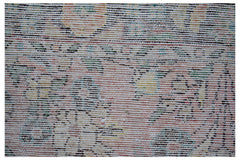 A close-up view of a vintage Persian rug featuring a faded, intricate floral pattern in wool.