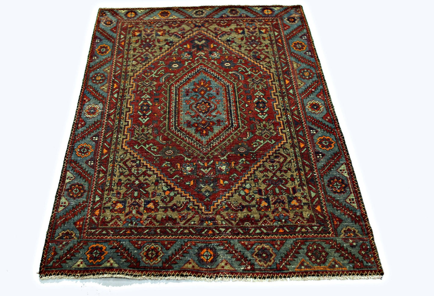 A rectangular vintage Persian rug featuring a central medallion with intricate red and blue patterns.