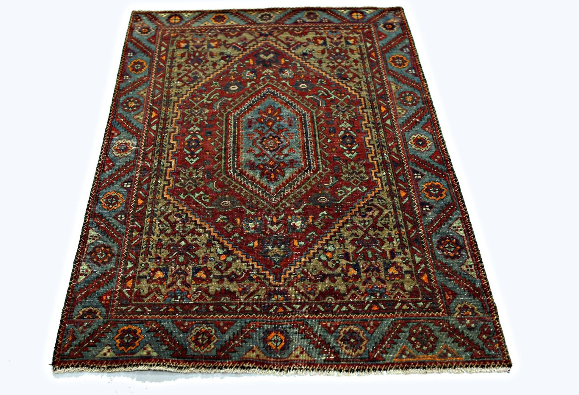A rectangular vintage Persian rug featuring a central medallion with intricate red and blue patterns.