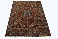 A rectangular vintage Persian rug featuring a central medallion with intricate red and blue patterns.