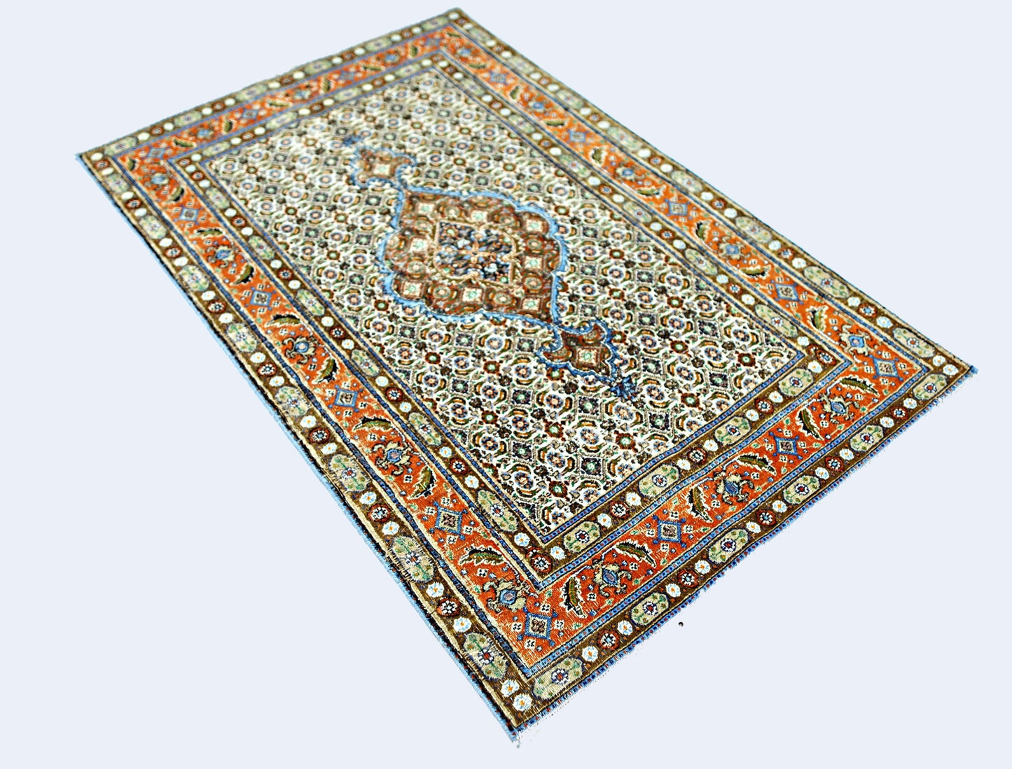 A rectangular vintage Persian rug featuring an intricate floral pattern in orange, blue, and cream.
