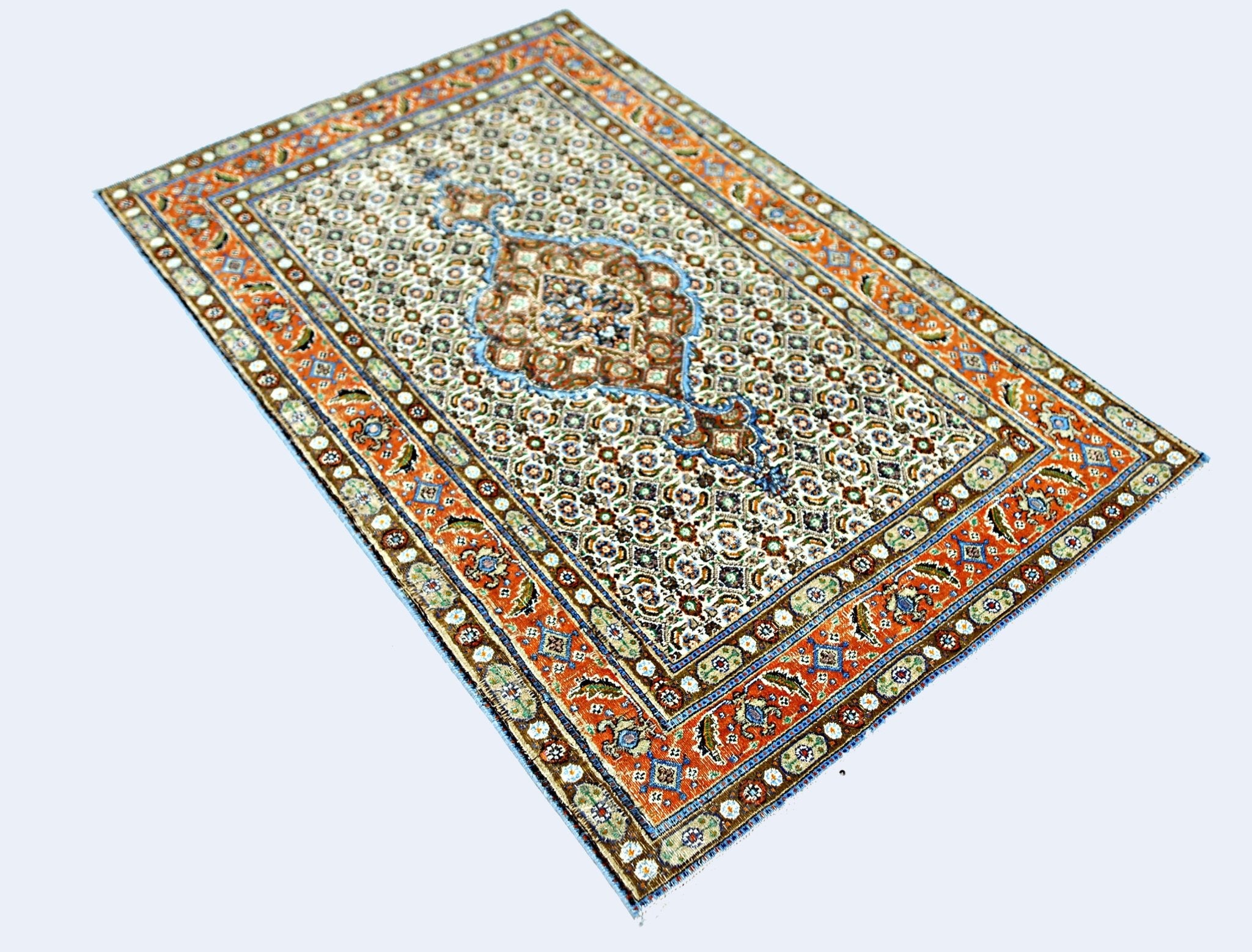 A rectangular vintage Persian rug featuring an intricate floral pattern in orange, blue, and cream.