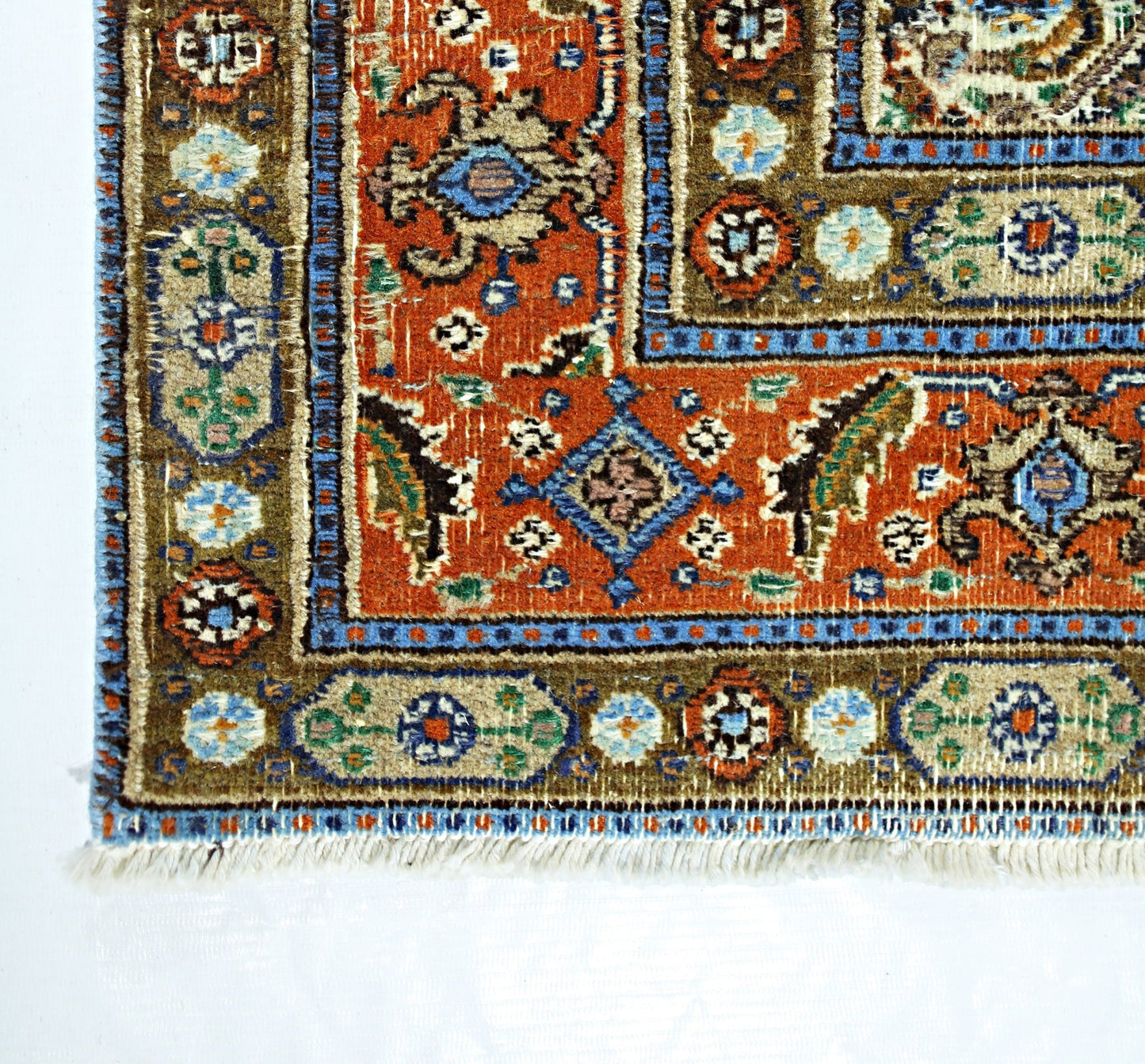 A vintage handmade Persian rug featuring intricate geometric patterns in orange, blue, and tan.