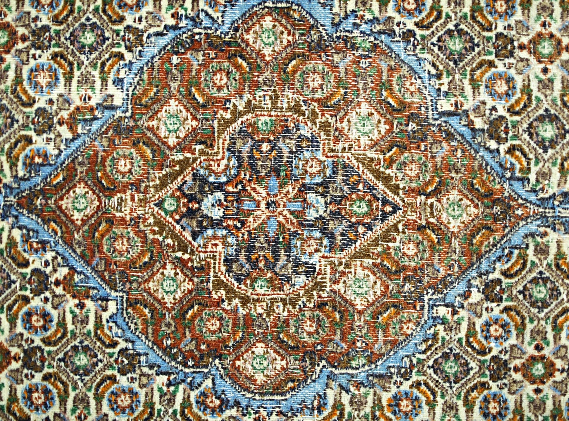 A vintage Persian rug featuring an intricate geometric medallion pattern in blue, red, and brown.
