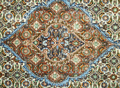 A vintage Persian rug featuring an intricate geometric medallion pattern in blue, red, and brown.