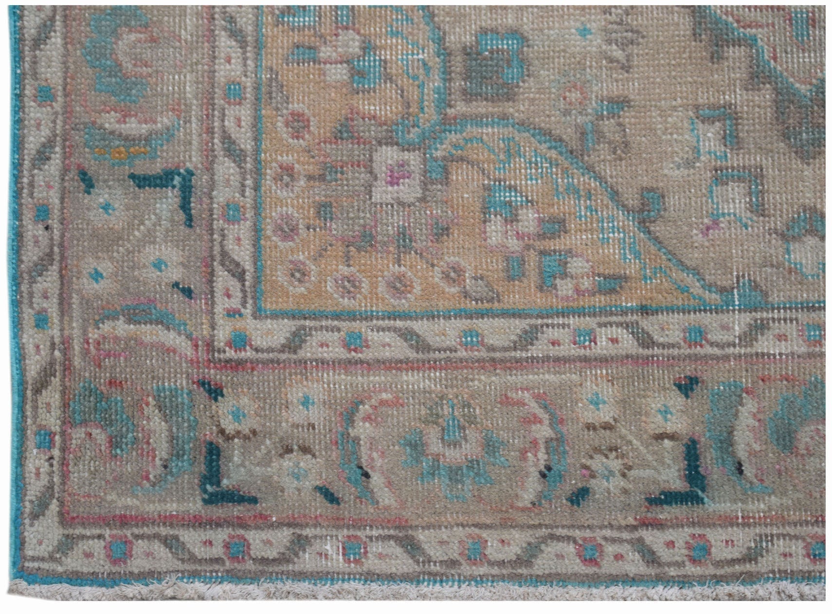A vintage Persian rug featuring a faded floral pattern in muted beige, blue, and pink tones.