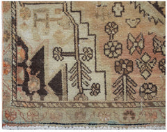 A vintage handwoven Persian rug featuring geometric floral motifs in muted earth tones.