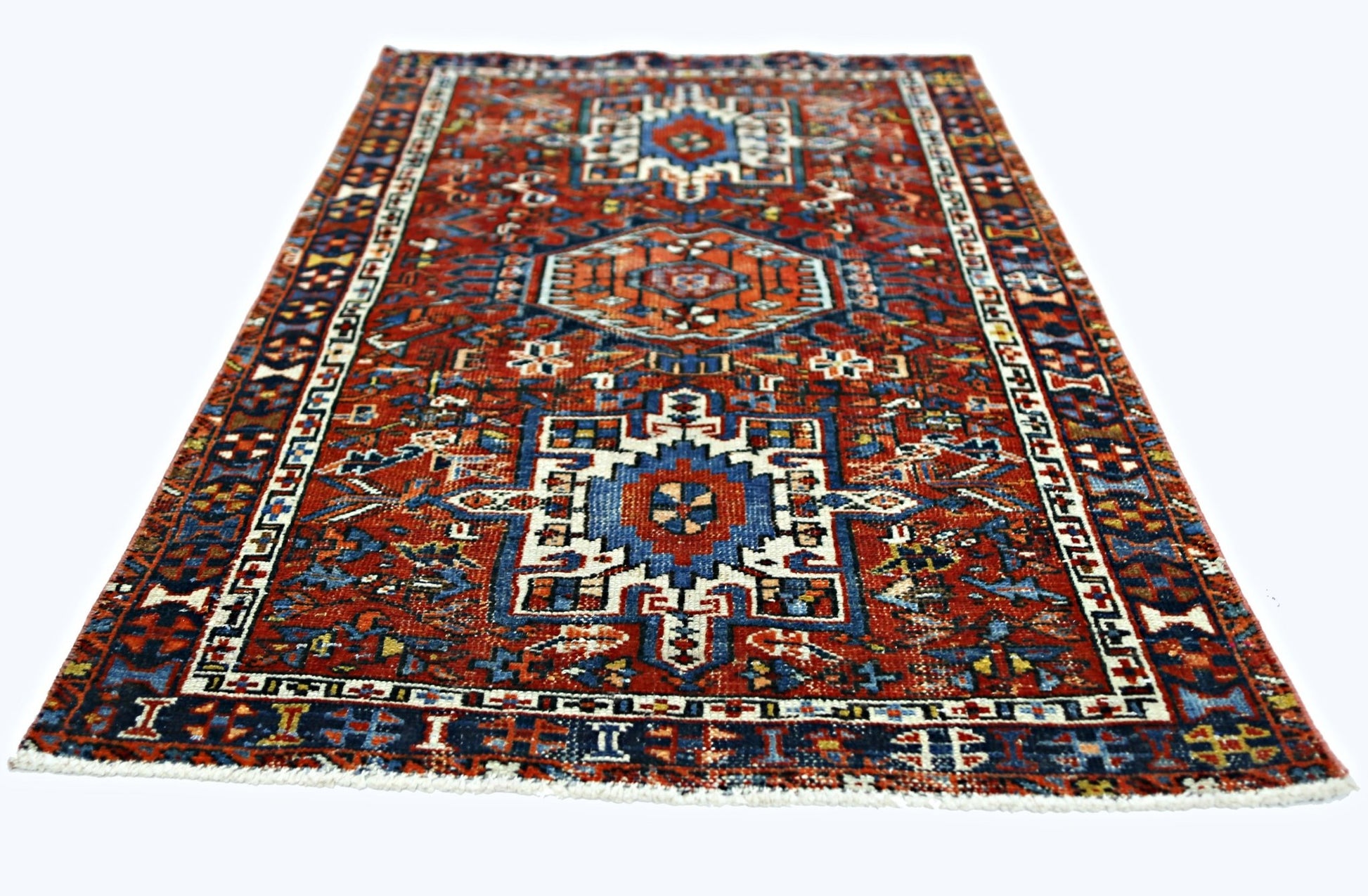 A rectangular vintage Persian rug featuring a geometric pattern in red, blue, and white.