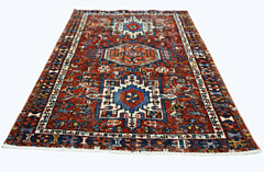 A rectangular vintage Persian rug featuring a geometric pattern in red, blue, and white.