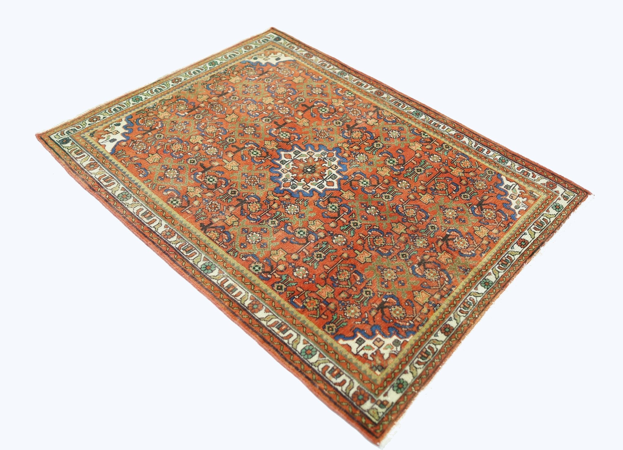 A rectangular vintage Persian rug featuring an intricate floral pattern in red, blue, and green.