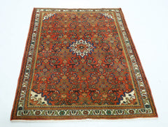 A rectangular vintage Persian rug featuring a detailed floral pattern in red, blue, and green.