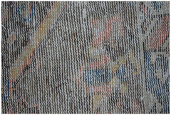 A close-up view of a handwoven vintage Persian rug featuring a worn, multi-colored wool pattern.
