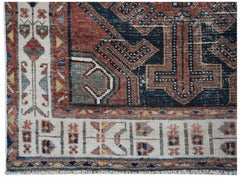 A handwoven vintage Persian rug featuring a geometric pattern in red, blue, and cream tones.