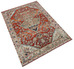 Vintage Persian rug with intricate floral patterns in red and cream.