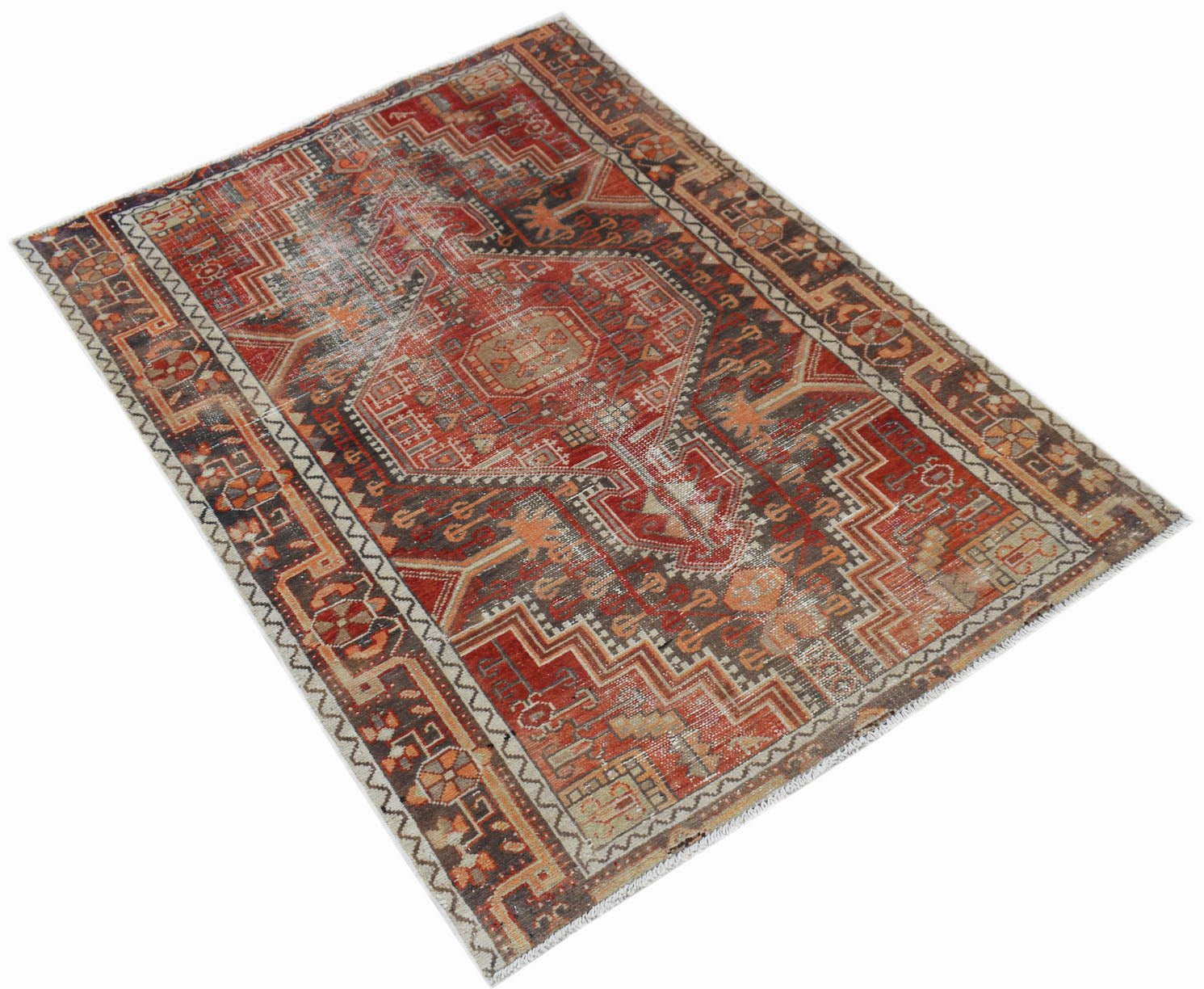 A rectangular vintage Persian rug featuring a geometric pattern in shades of red, brown, and cream.