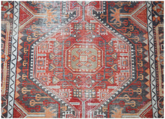 A vintage handwoven Persian rug featuring a geometric medallion pattern in red, grey, and orange.