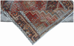 A handwoven vintage Persian rug featuring intricate geometric patterns in red, brown, and beige.