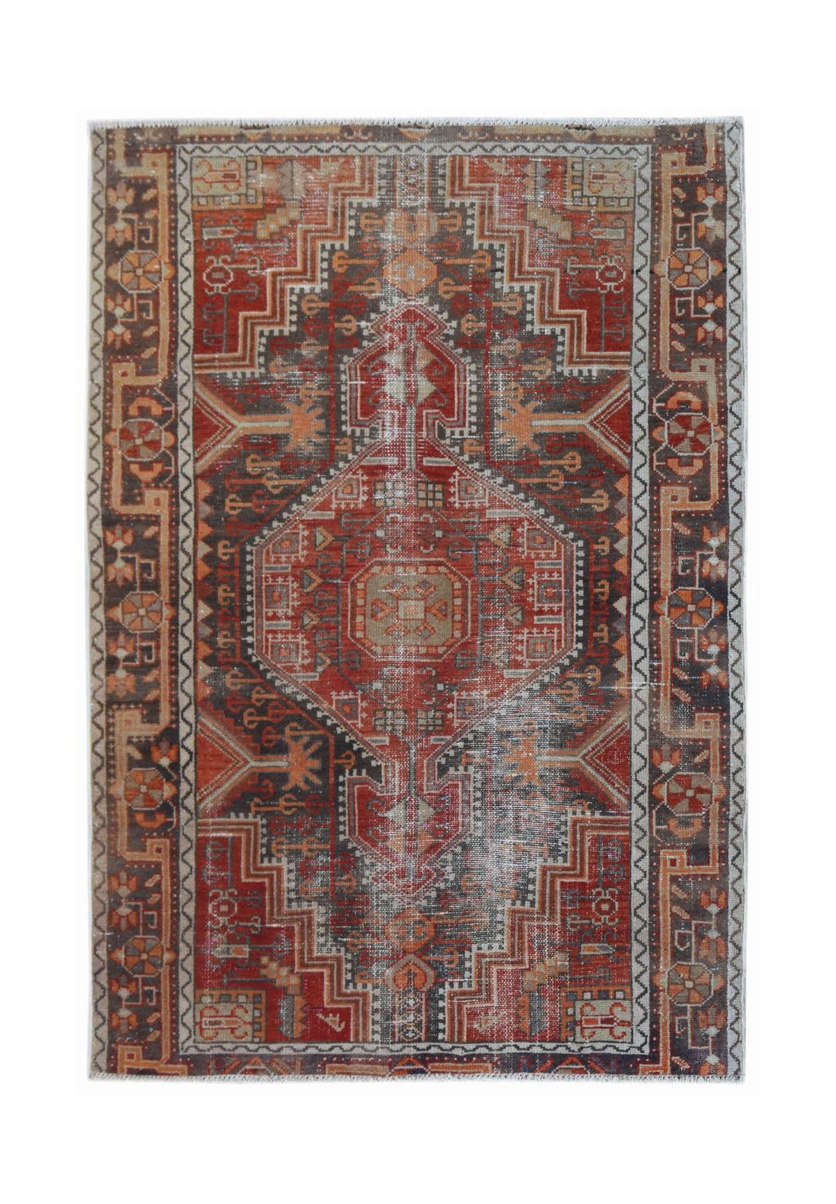A rectangular vintage Persian rug featuring a geometric medallion pattern in red and charcoal tones.