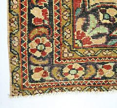 A corner view of a handmade vintage Persian rug featuring intricate floral patterns in warm tones.