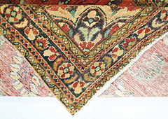 A folded vintage Persian rug featuring intricate floral patterns in red, gold, and green tones.