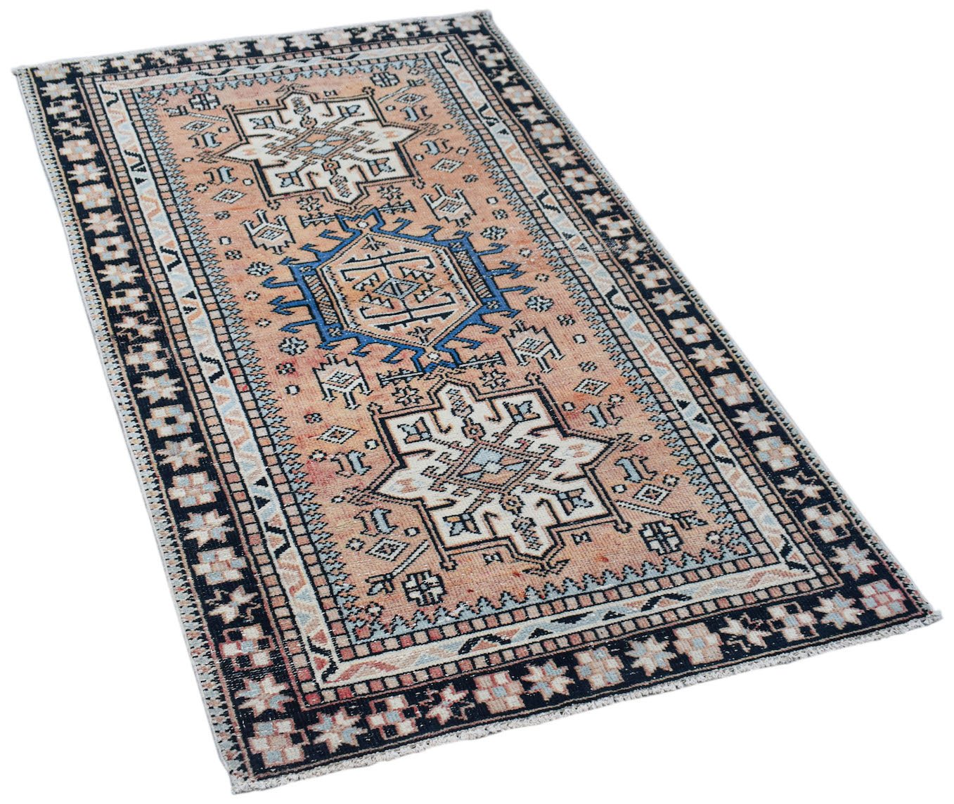A rectangular vintage Persian rug featuring geometric patterns in peach, blue, and cream tones.