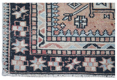 A close-up of a vintage Persian rug featuring geometric patterns in muted red, blue, and black.