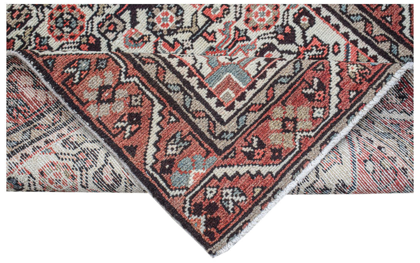 A handwoven vintage Persian rug featuring a geometric floral pattern in red, blue, and cream.