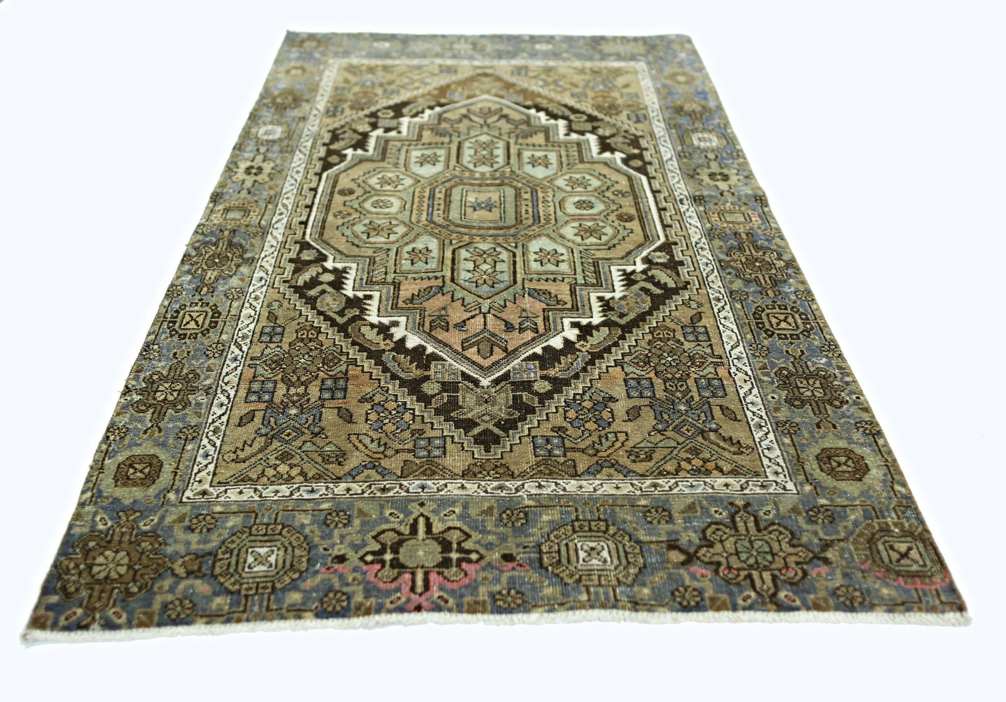 A rectangular vintage Persian rug featuring a geometric medallion pattern in muted earth tones.