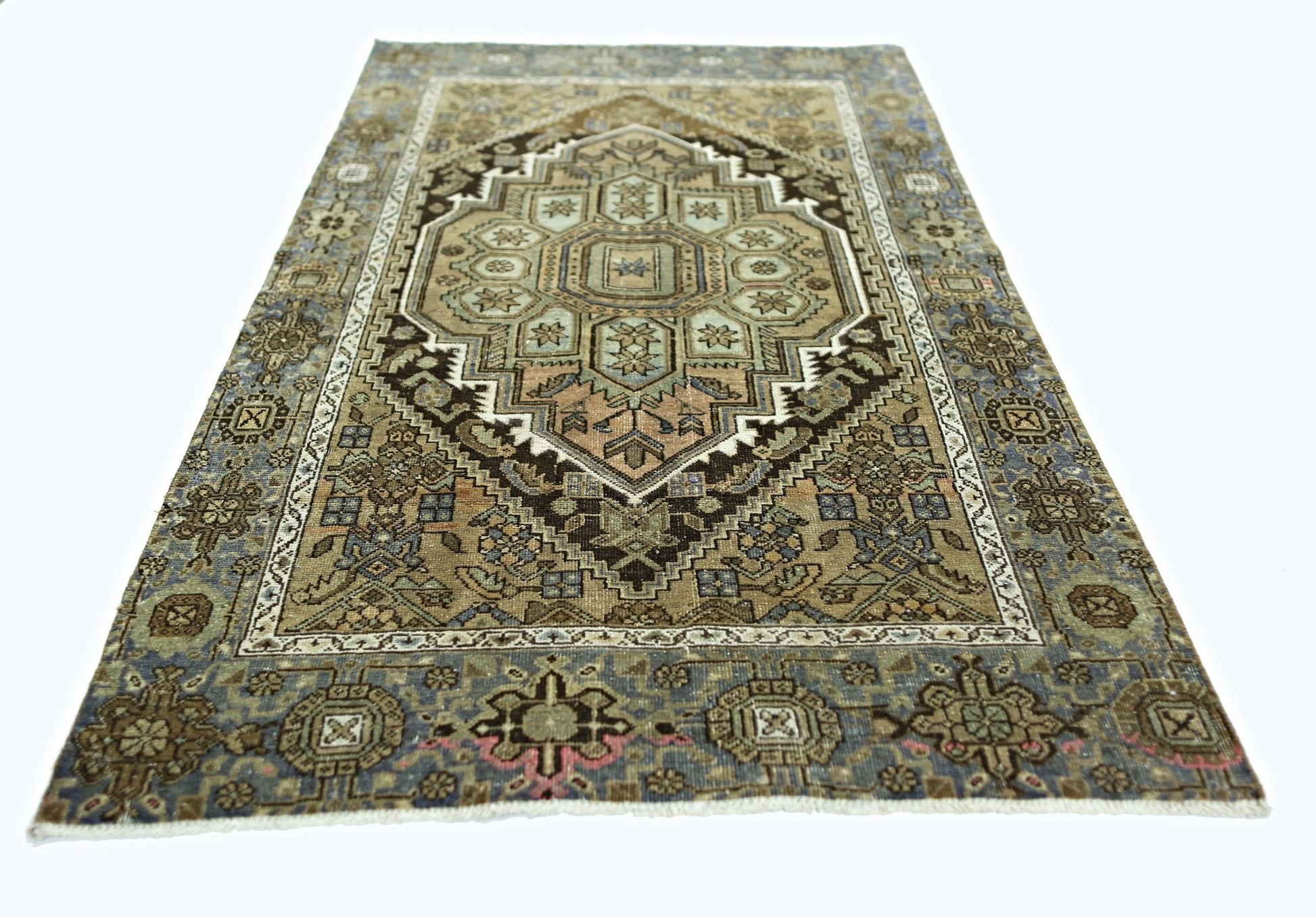 A rectangular vintage Persian rug featuring a geometric medallion pattern in muted earth tones.