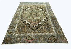 A rectangular vintage Persian rug featuring a geometric medallion pattern in muted earth tones.
