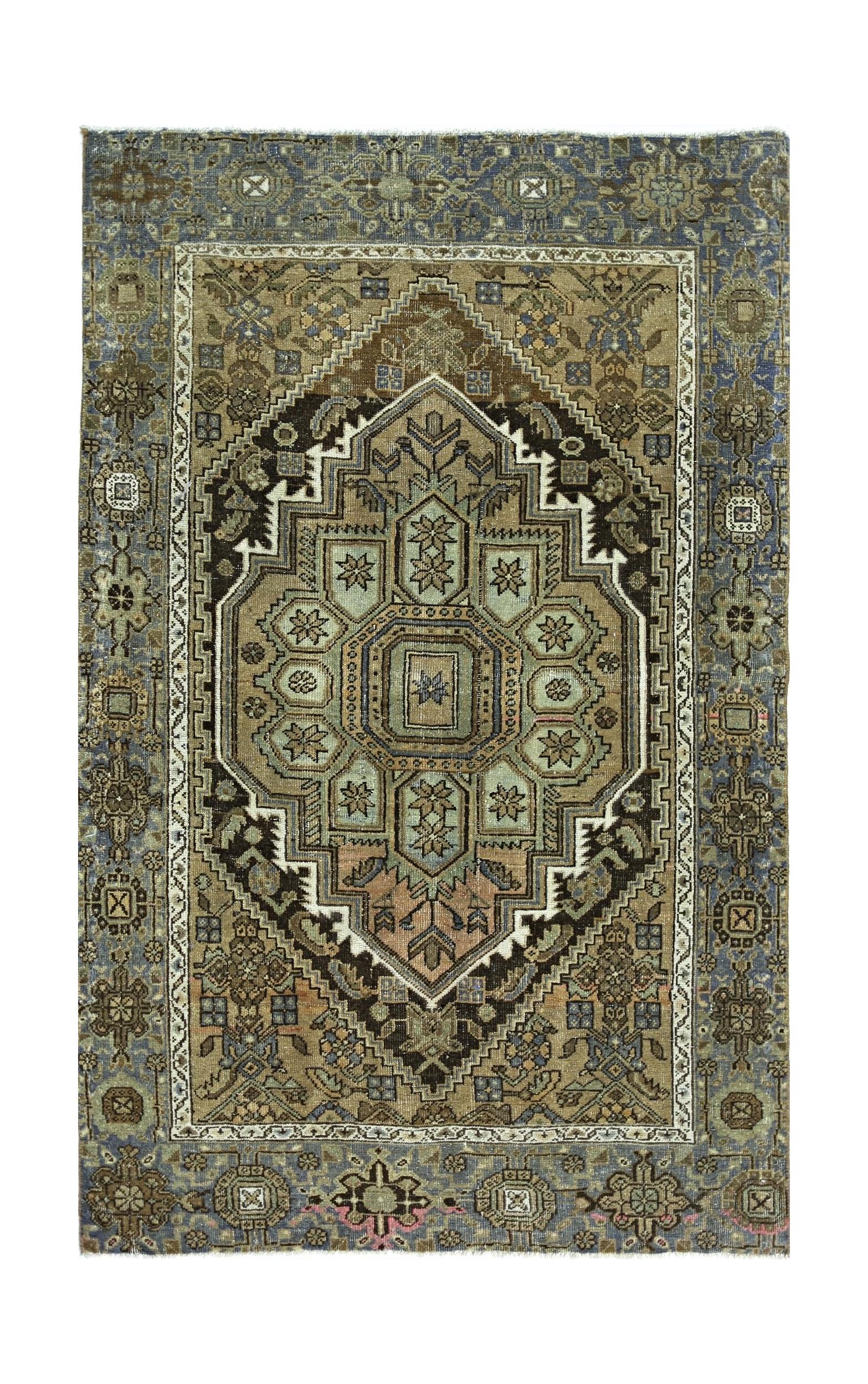 A vintage handmade Persian rug featuring a central geometric medallion in muted earth tones.