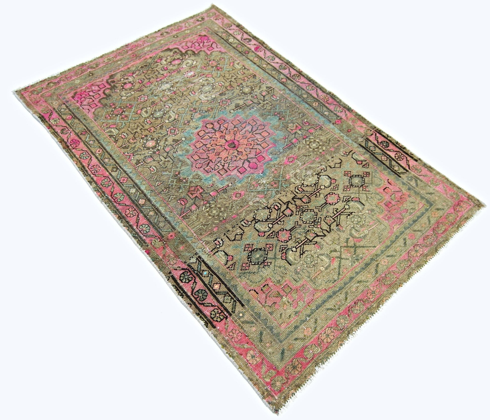 A vintage handmade Persian rug featuring a central floral medallion in pink and blue on a tan field.