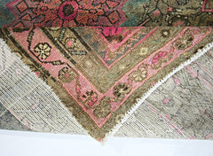 A corner of a vintage handmade Persian rug showing its wool pile and cotton foundation.