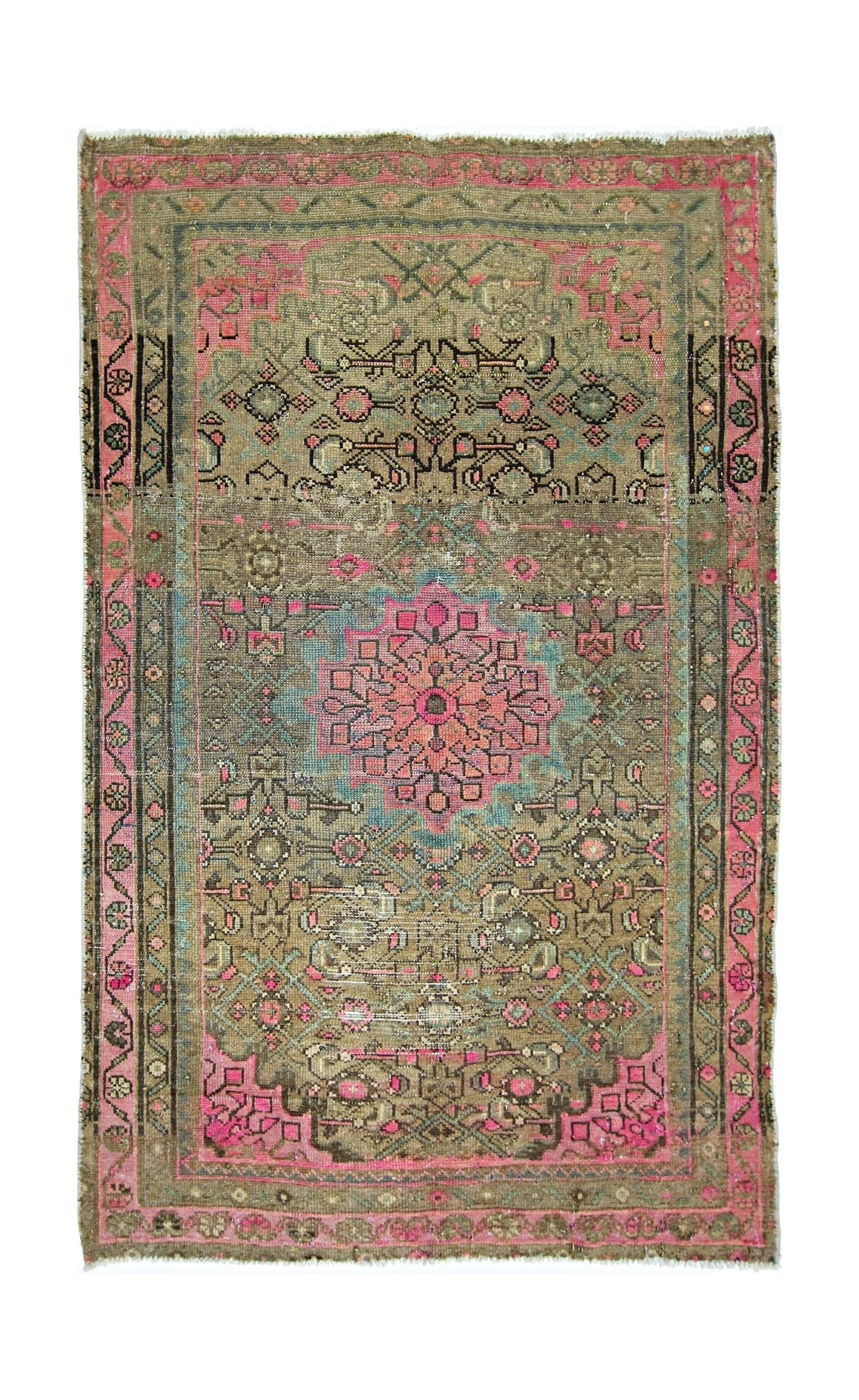 A vintage handmade Persian rug featuring a central pink floral medallion on a muted olive field.