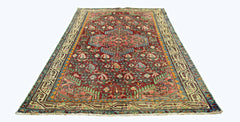 A rectangular vintage Persian rug with a red field, intricate floral patterns, and geometric borders.