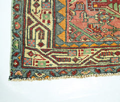 A corner view of a handmade vintage Persian rug featuring intricate geometric patterns in wool.