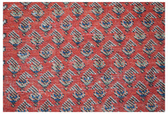 A vintage handwoven Persian rug featuring a repeating paisley pattern on a vibrant red background.