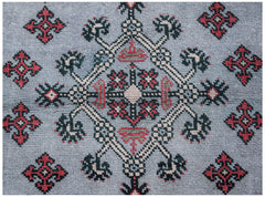 A vintage Persian rug featuring a central geometric medallion in red, black, and beige on grey.