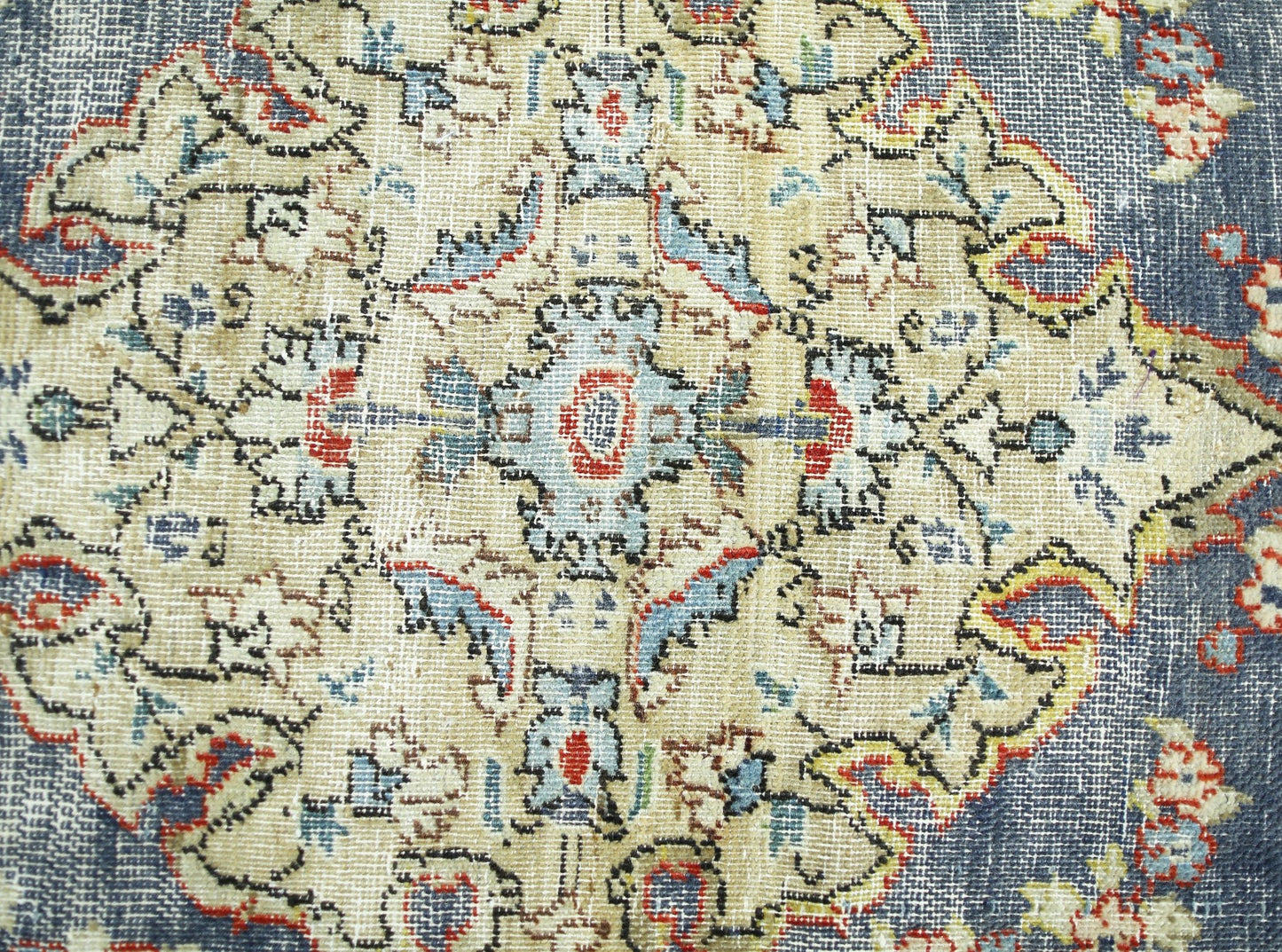 A vintage Persian rug featuring a detailed floral medallion pattern in blue, red, and cream tones.