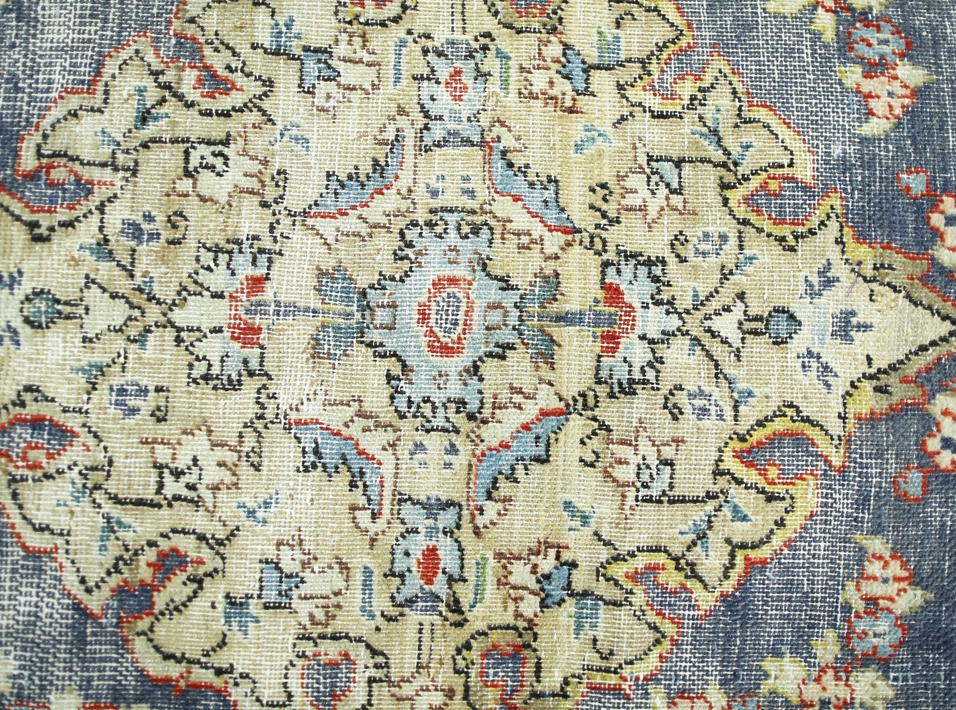 A vintage Persian rug featuring a detailed floral medallion pattern in blue, red, and cream tones.
